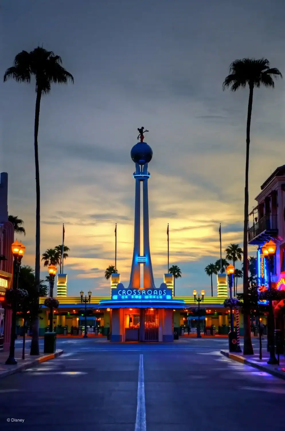 Disney Hollywood Studios Crossroads entrance at sunset with palm trees